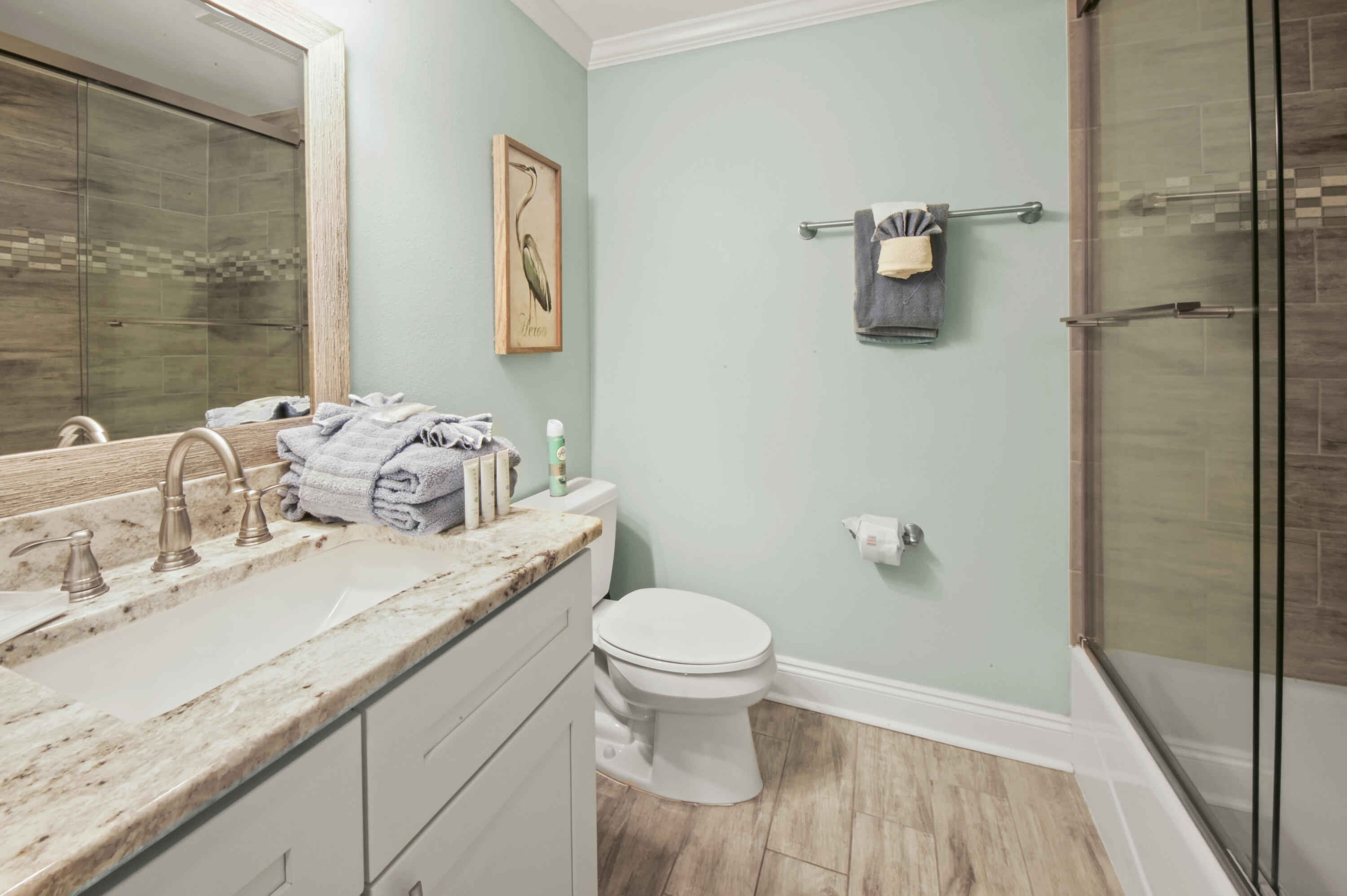 8477 Gulf Boulevard, Unit 902 Navarre, FL 32566 - Photo 21 of 36 a bathroom with a granite countertop sink a toilet and a mirror