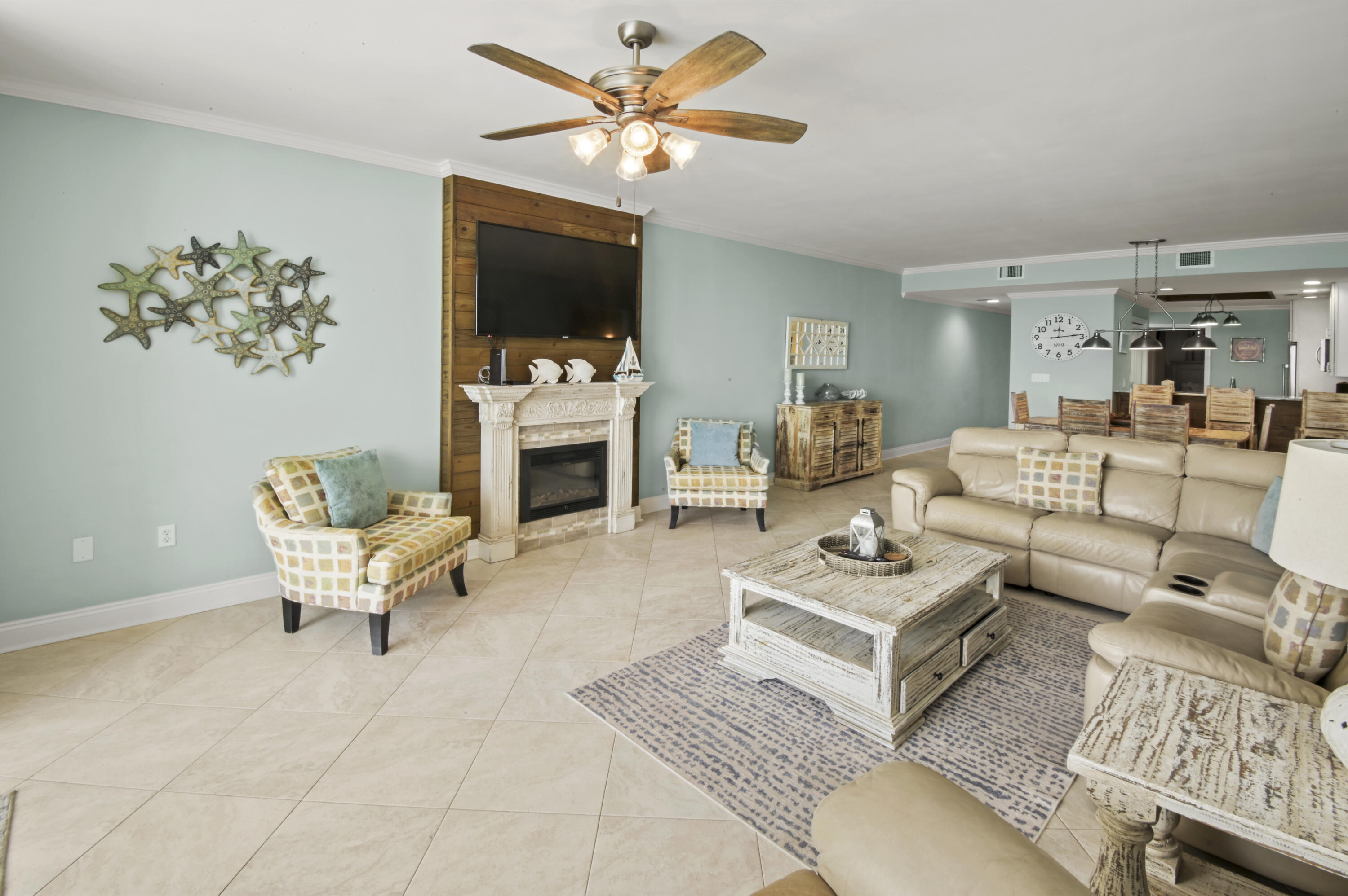 8477 Gulf Boulevard, Unit 902 Navarre, FL 32566 - Photo 3 of 36 a living room with furniture a flat screen tv and a fireplace