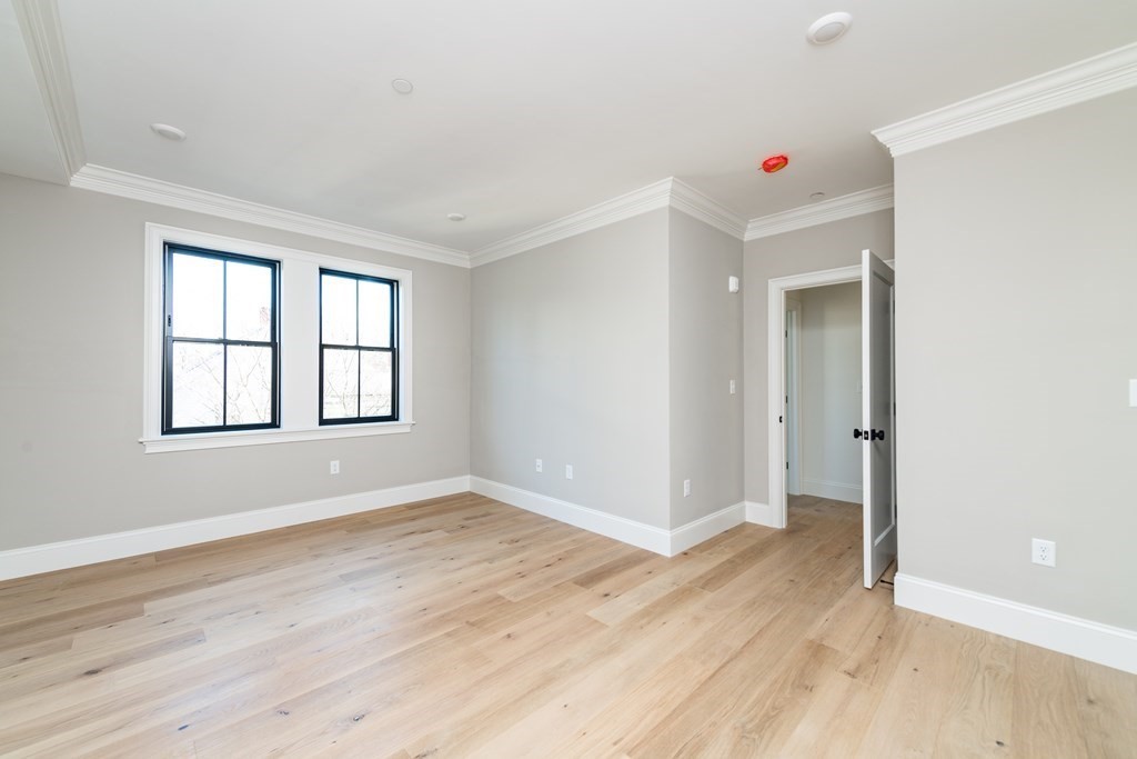 120 Brookside Avenue, Unit 203 Boston, MA 02130 - Photo 11 of 18 an empty room with wooden floor and windows