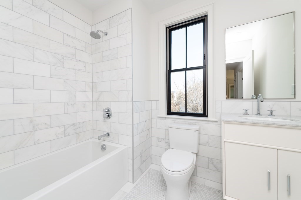 120 Brookside Avenue, Unit 203 Boston, MA 02130 - Photo 12 of 18 a bathroom with a sink toilet a mirror and bathtub