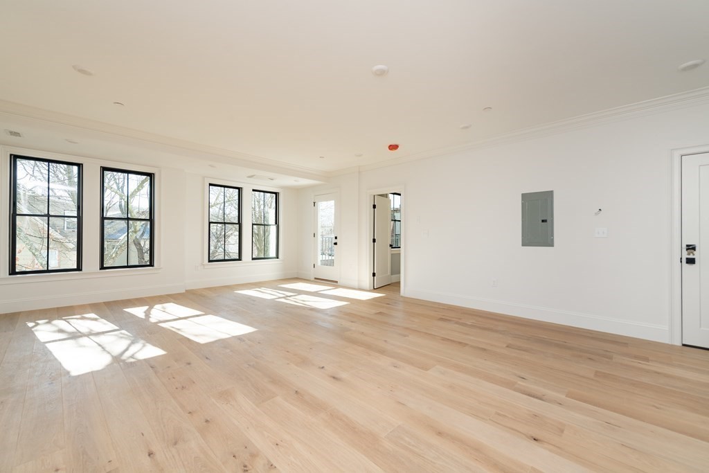 120 Brookside Avenue, Unit 203 Boston, MA 02130 - Photo 2 of 18 a view of an empty room with window and wooden floor