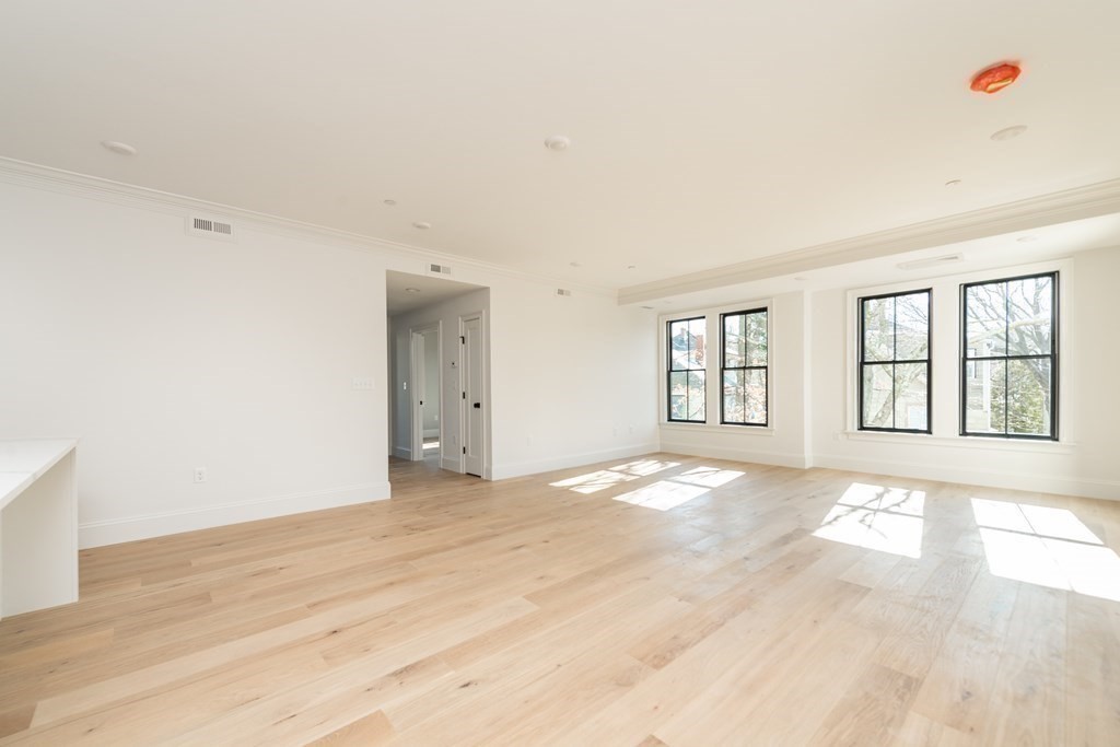 120 Brookside Avenue, Unit 203 Boston, MA 02130 - Photo 8 of 18 a view of an empty room with wooden floor and a window