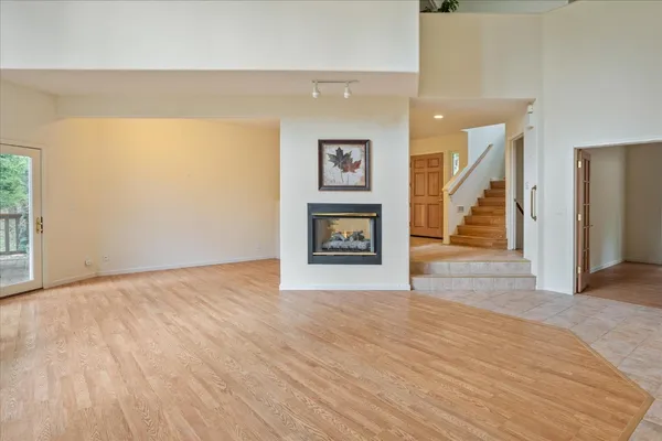 a living room with furniture wooden floor and a kitchen view