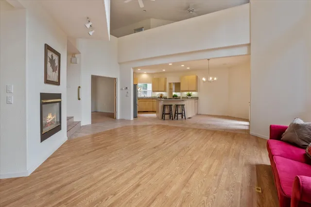 a kitchen with stainless steel appliances granite countertop a stove top oven a sink dishwasher and a refrigerator with wooden floor