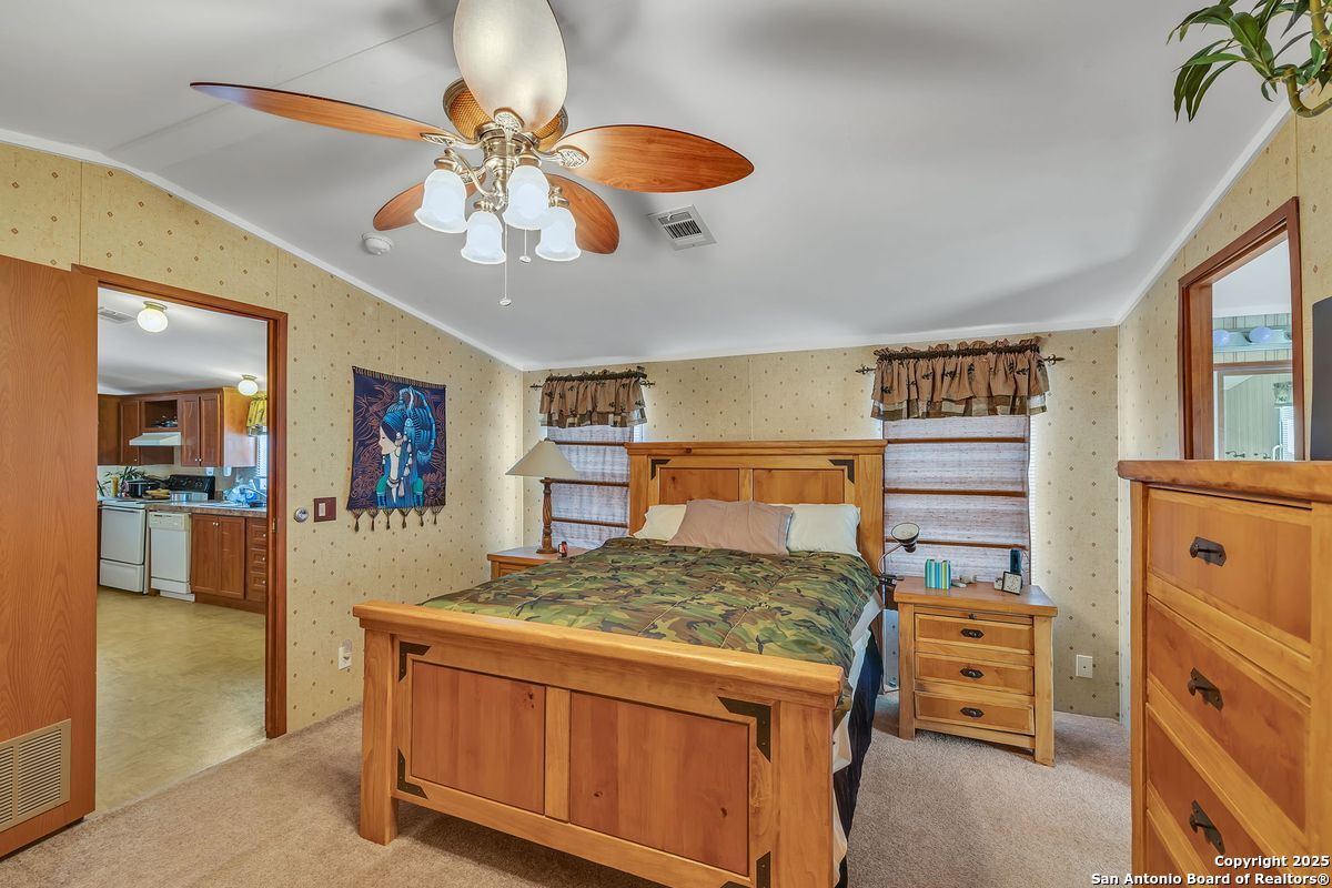 2654 Mathews Rnch Road Dilley, TX 78017 - Photo 28 of 39 a bedroom with a bed and a chandelier