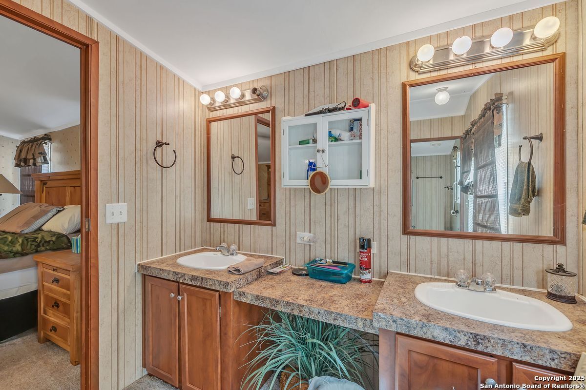2654 Mathews Rnch Road Dilley, TX 78017 - Photo 29 of 39 a bathroom with a granite countertop sink mirror and a shower
