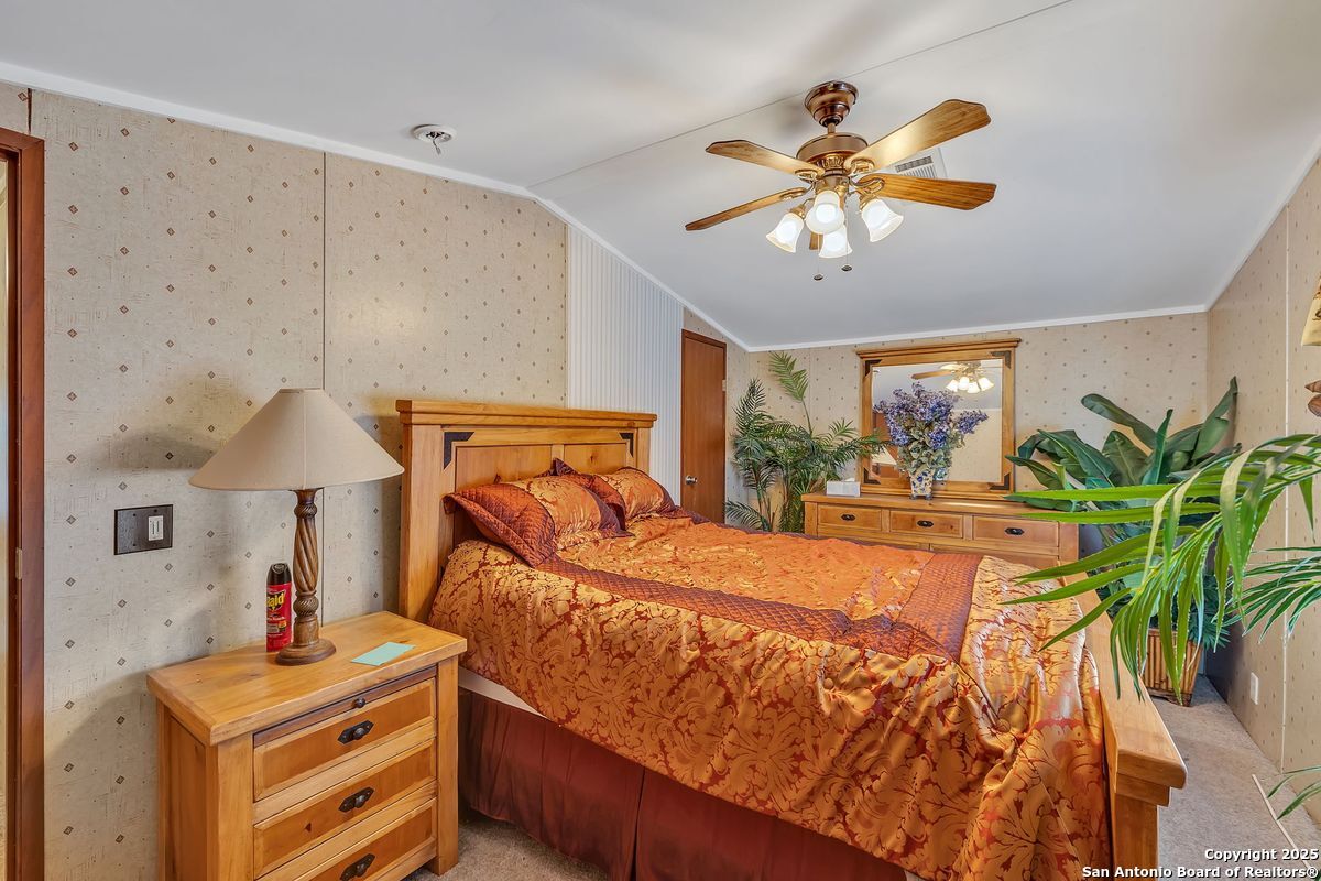 2654 Mathews Rnch Road Dilley, TX 78017 - Photo 31 of 39 a bed room with a bed and a chandelier