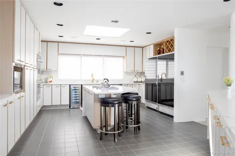a kitchen with granite countertop a sink counter top space appliances and a window