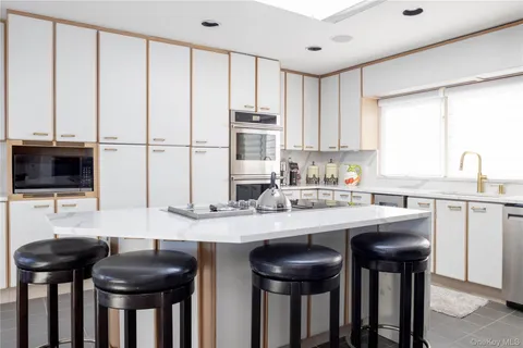 a kitchen with stainless steel appliances granite countertop a table and chairs in it