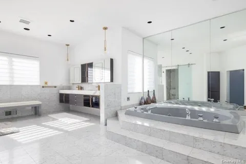 a bathroom with a double vanity sink a mirror and a bathtub