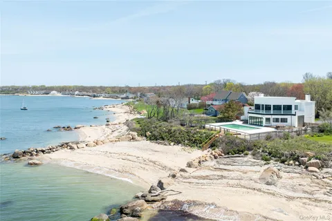 an aerial view of a house with a yard and lake view