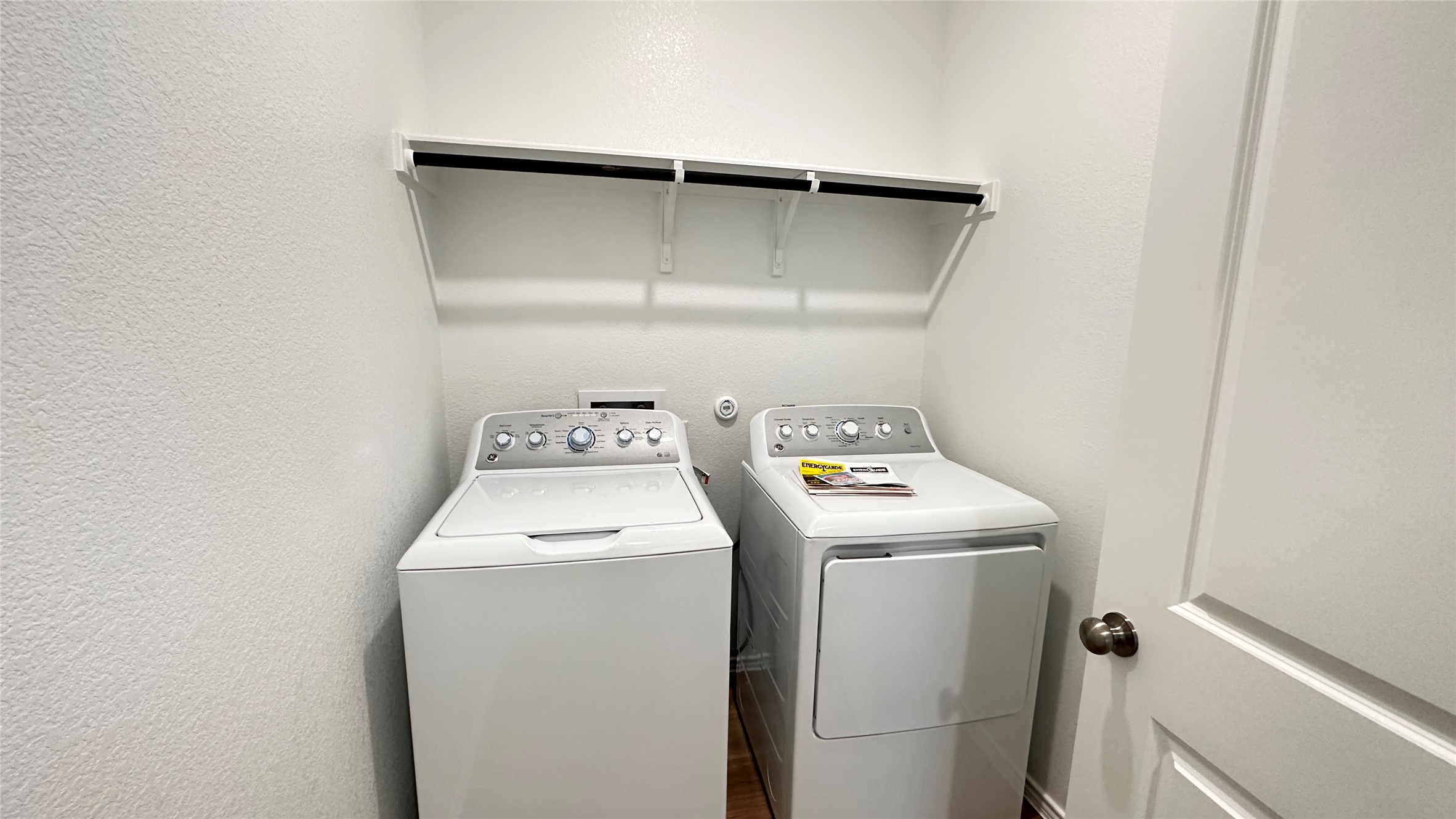 138 Milliner Loop Hutto, TX 78634 - Photo 11 of 36 Laundry room with washing machine and clothes dryer, a textured wall, and dark wood finished floors