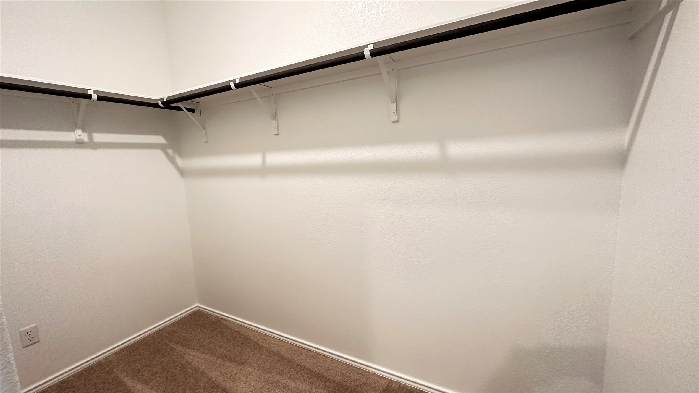 138 Milliner Loop Hutto, TX 78634 - Photo 19 of 36 Walk in closet featuring dark carpet