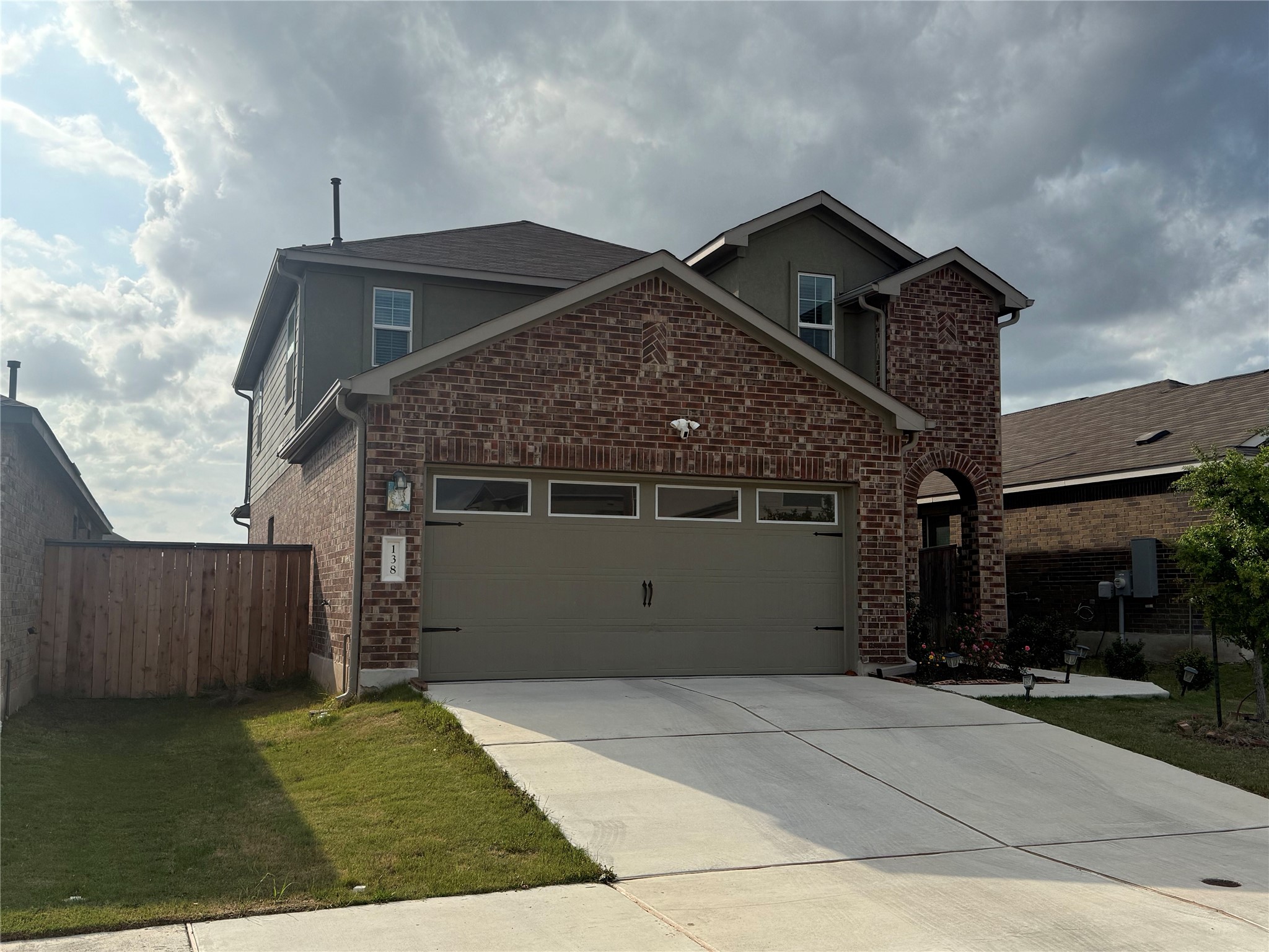 138 Milliner Loop Hutto, TX 78634 - Photo 2 of 36 Traditional home with a garage, driveway, and brick siding