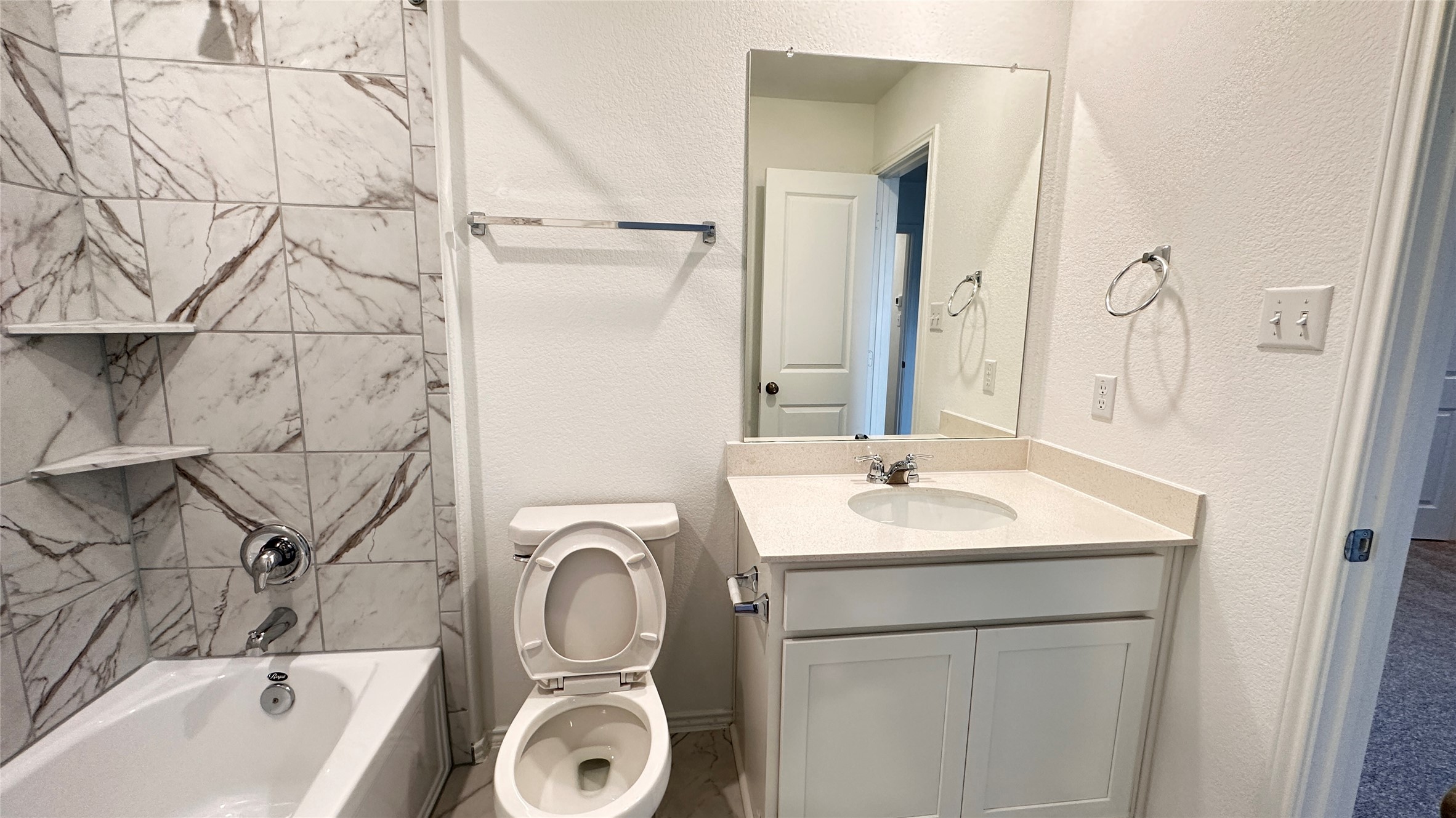 138 Milliner Loop Hutto, TX 78634 - Photo 30 of 36 Full bathroom featuring a textured wall, vanity, and bathing tub / shower combination