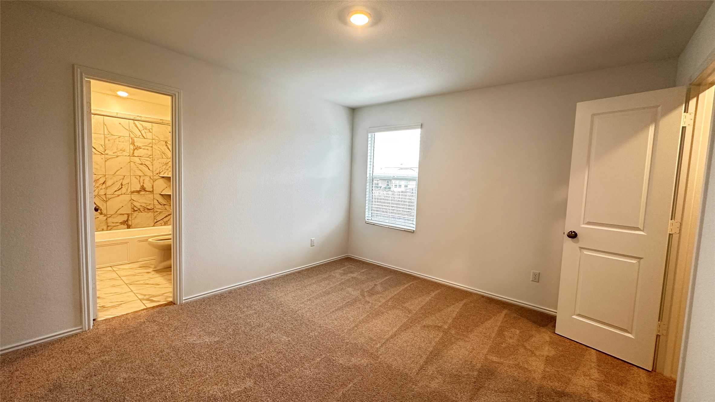 138 Milliner Loop Hutto, TX 78634 - Photo 31 of 36 Unfurnished bedroom with light colored carpet and ensuite bath