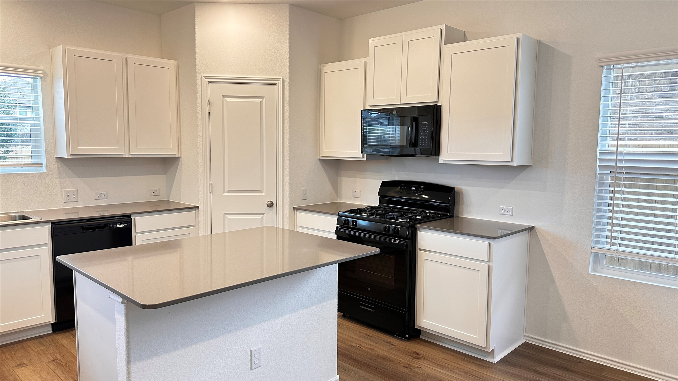 138 Milliner Loop Hutto, TX 78634 - Photo 8 of 36 Kitchen with black appliances, white cabinets, and a center island