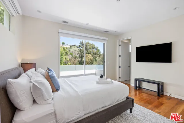 a bedroom with a bed and a flat screen tv
