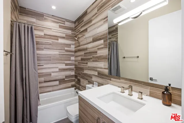a bathroom with a sink shower and a mirror