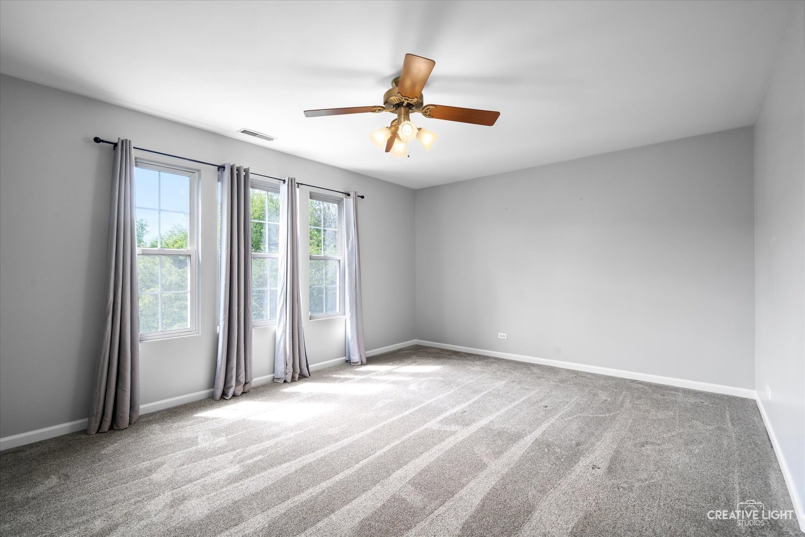 2296 Reflections Drive, Unit 2296 Aurora, IL 60502 - Photo 19 of 32 an empty room with windows and ceiling fan
