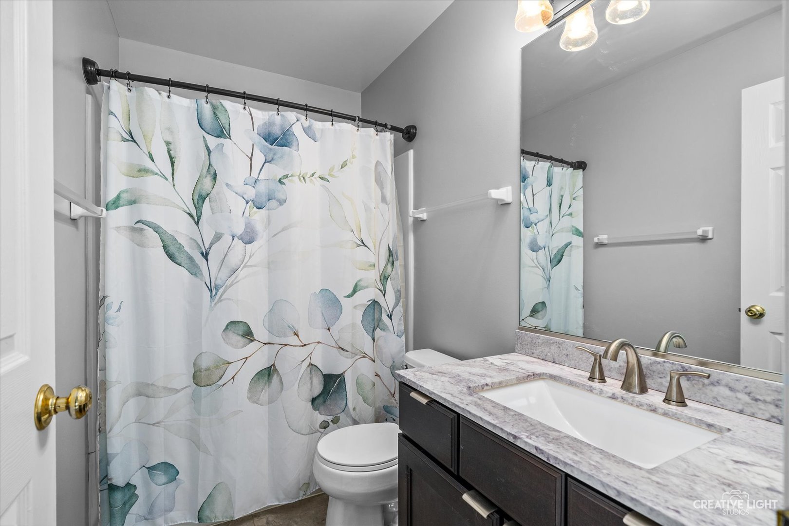 2296 Reflections Drive, Unit 2296 Aurora, IL 60502 - Photo 27 of 32 a bathroom with a granite countertop sink a toilet and a mirror