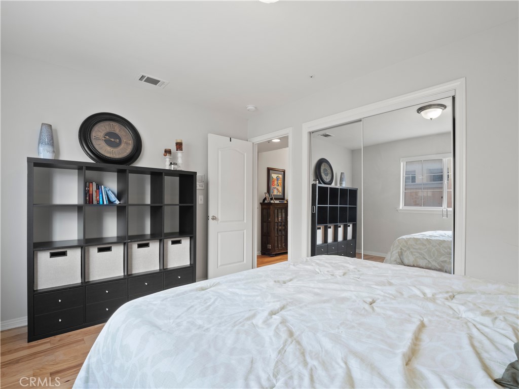 2517 Rockefeller Lane, Unit B Redondo Beach, CA 90278 - Photo 23 of 36 a bedroom with a bed and a closet with wooden floor