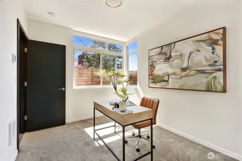 a view of a workspace with furniture and window