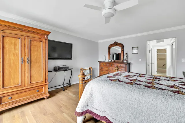 a bedroom with a bed and a flat tv screen on dresser