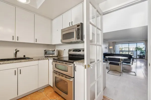 a kitchen with cabinets stainless steel appliances and a counter space