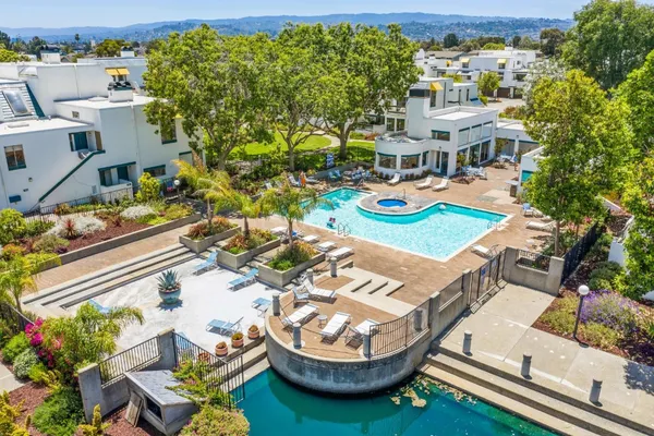 an aerial view of a house with swimming pool and outdoor seating