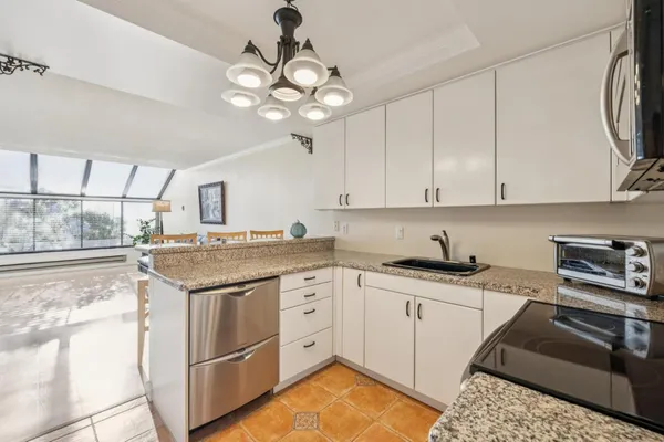 a kitchen with stainless steel appliances granite countertop a sink a stove and cabinets