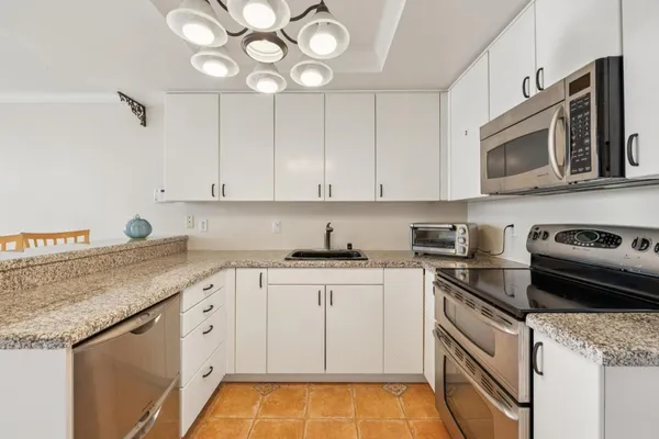 a kitchen with stainless steel appliances granite countertop a sink and stove top oven