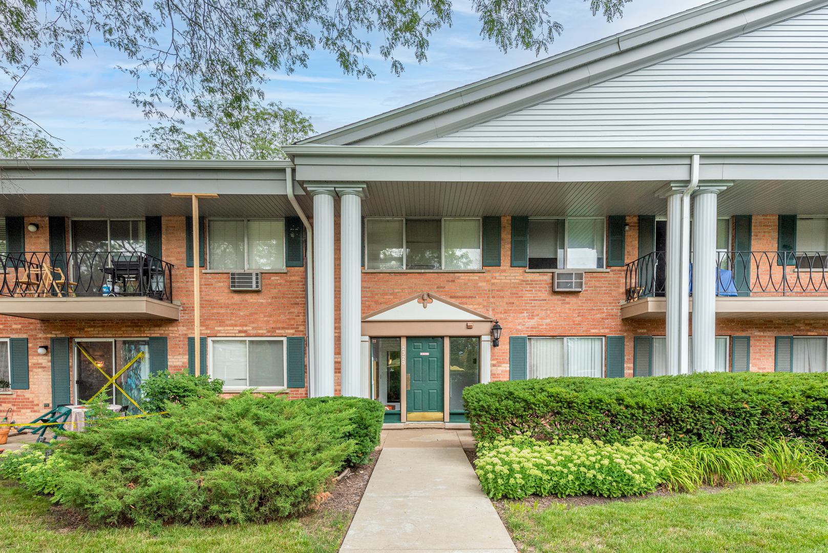 front view of a brick house with a small yard