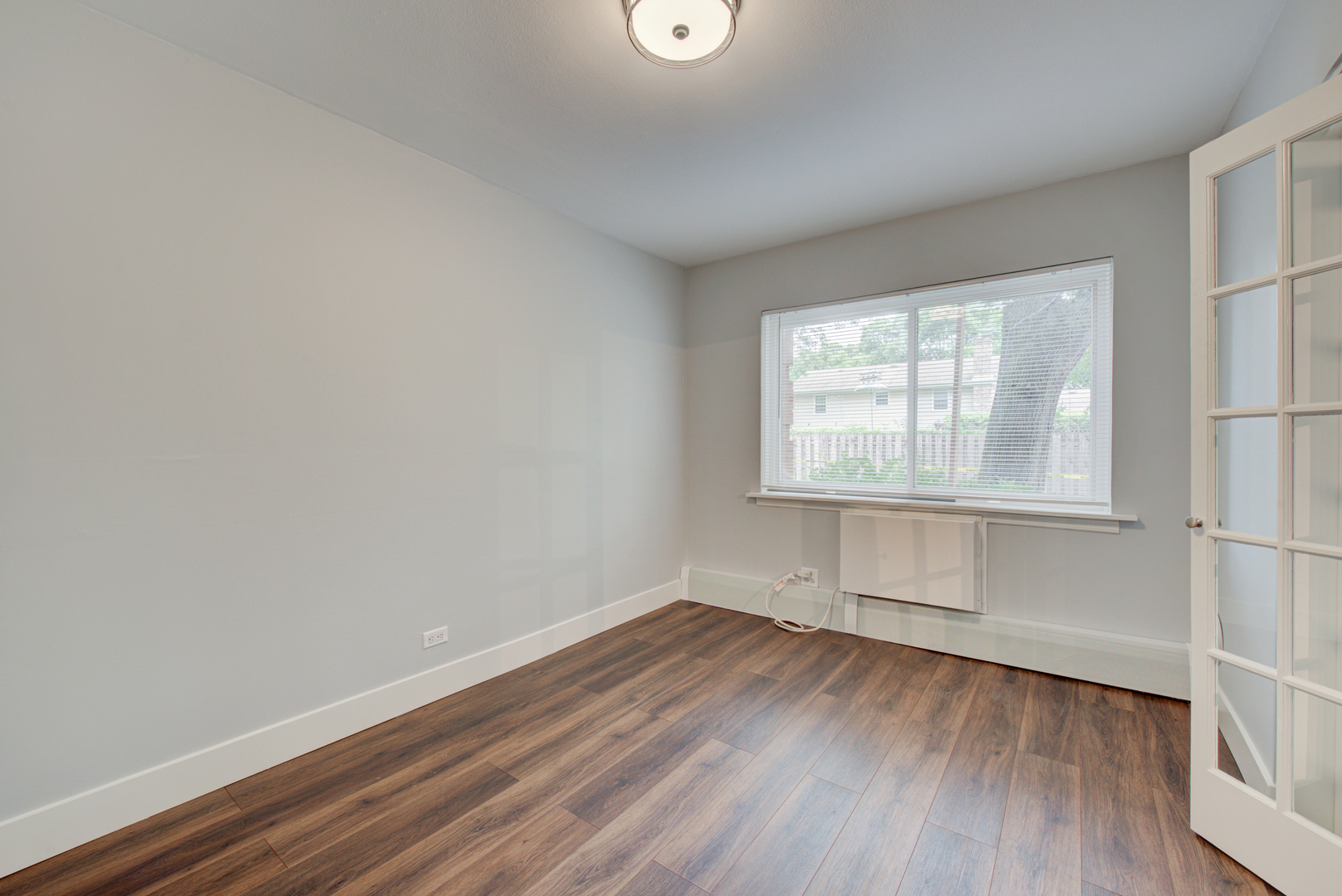 2323 South Goebbert Road, Unit 109 Arlington Heights, IL 60005 - Photo 11 of 22 an empty room with wooden floor and windows