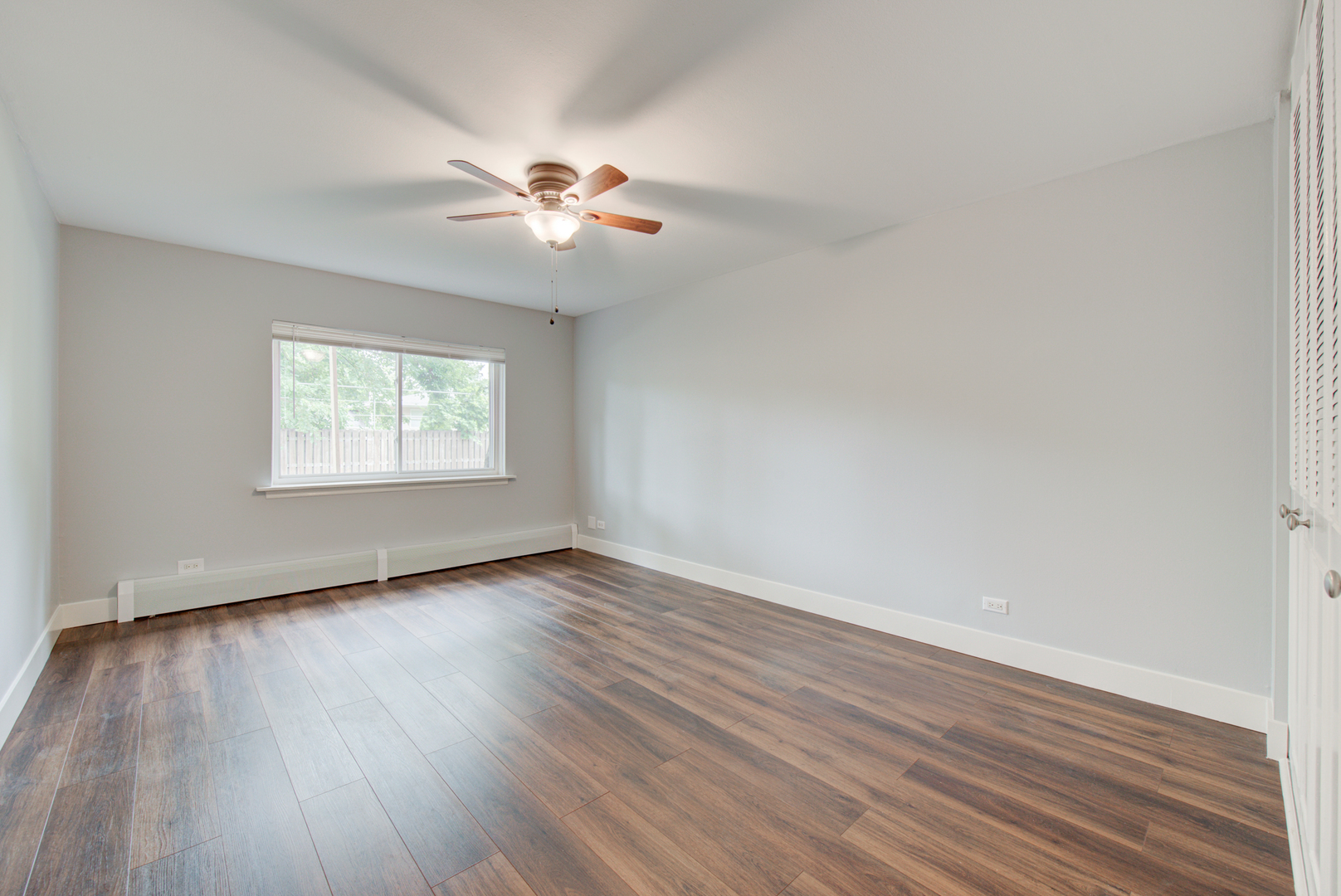 2323 South Goebbert Road, Unit 109 Arlington Heights, IL 60005 - Photo 12 of 22 a view of an empty room with wooden floor and a window