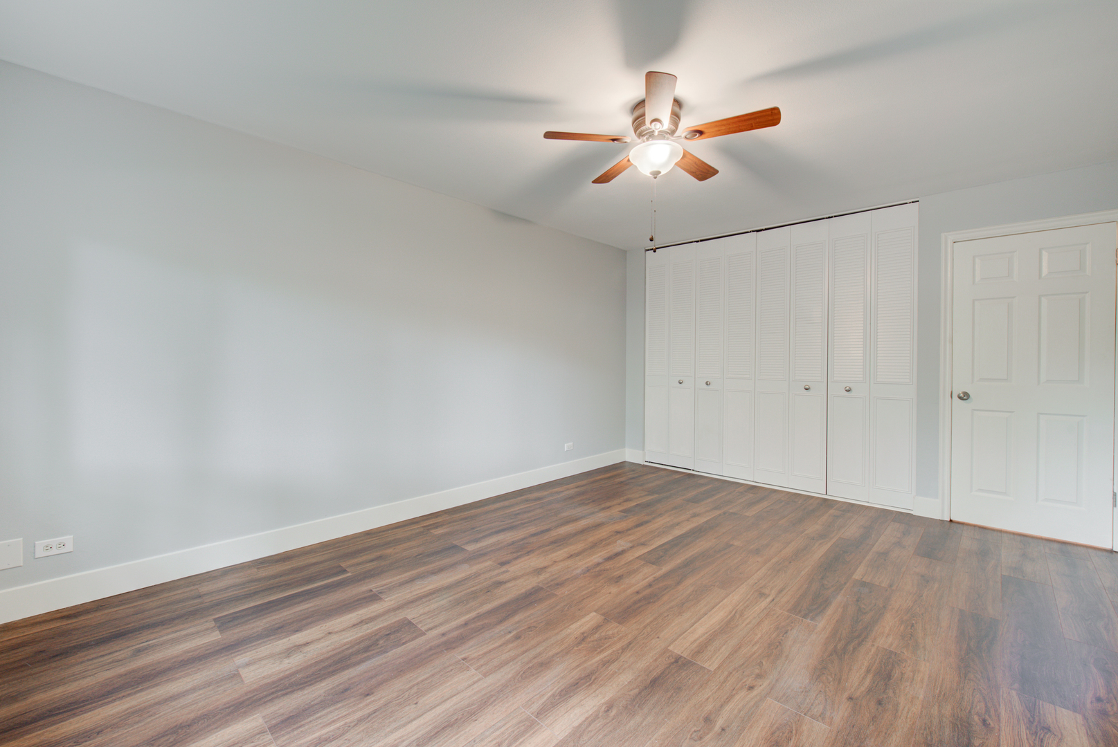 2323 South Goebbert Road, Unit 109 Arlington Heights, IL 60005 - Photo 13 of 22 an empty room with wooden floor fan and windows