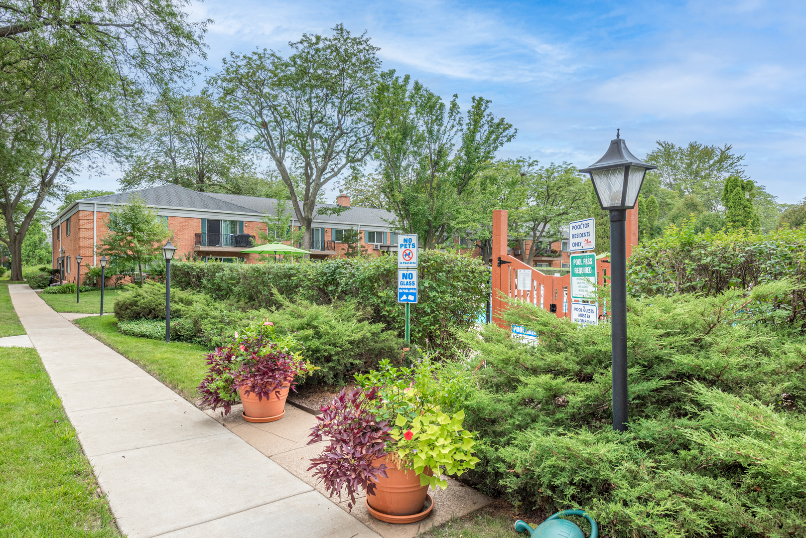 2323 South Goebbert Road, Unit 109 Arlington Heights, IL 60005 - Photo 17 of 22 a front view of a house with a yard and potted plants