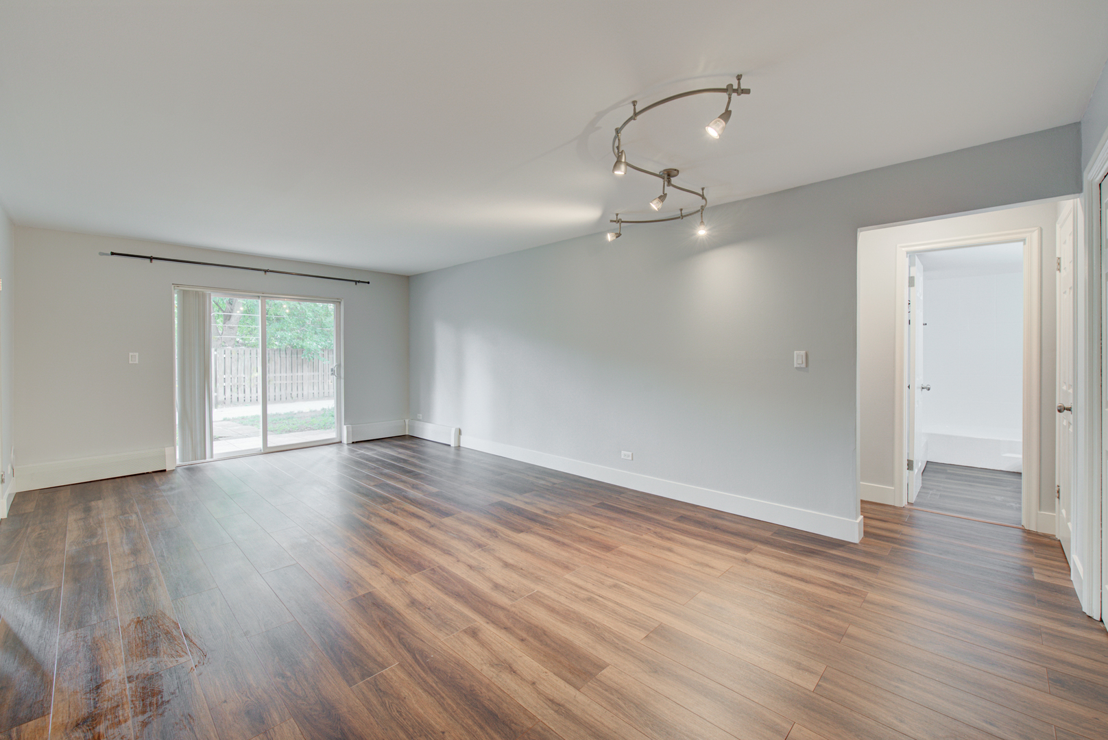 2323 South Goebbert Road, Unit 109 Arlington Heights, IL 60005 - Photo 5 of 22 a view of an empty room with wooden floor and a window