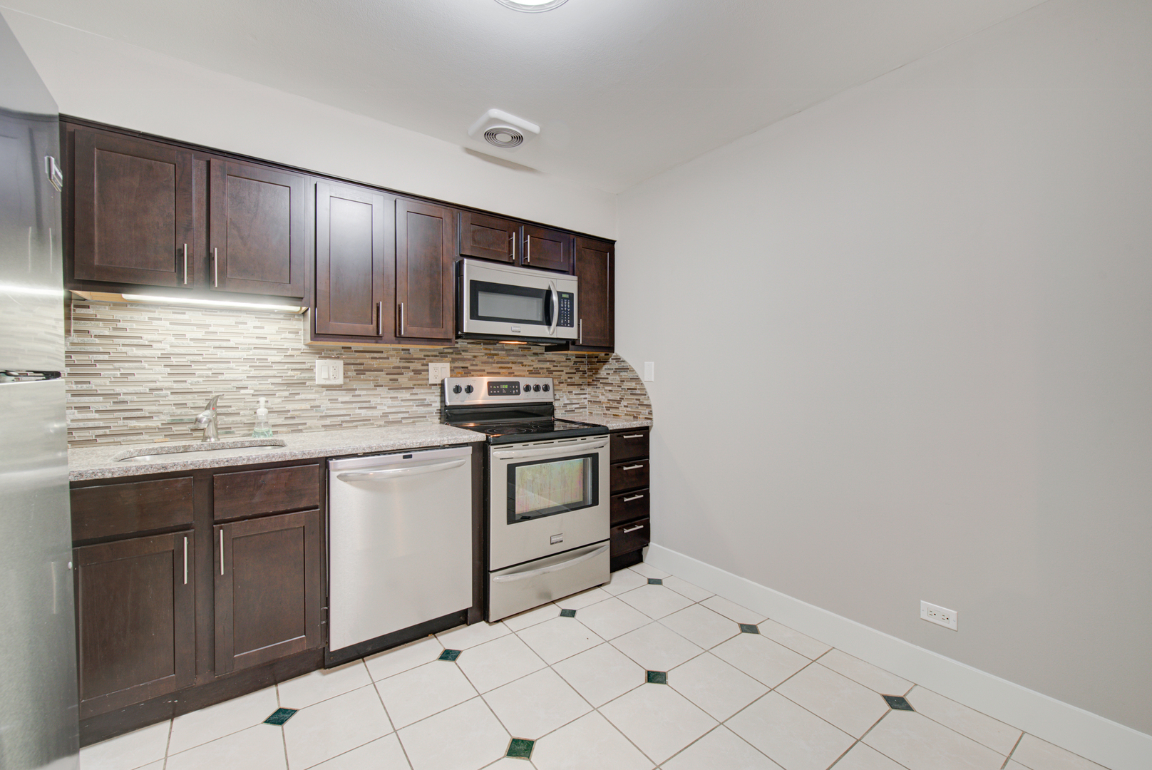 2323 South Goebbert Road, Unit 109 Arlington Heights, IL 60005 - Photo 8 of 22 a kitchen with white cabinets a sink and dishwasher