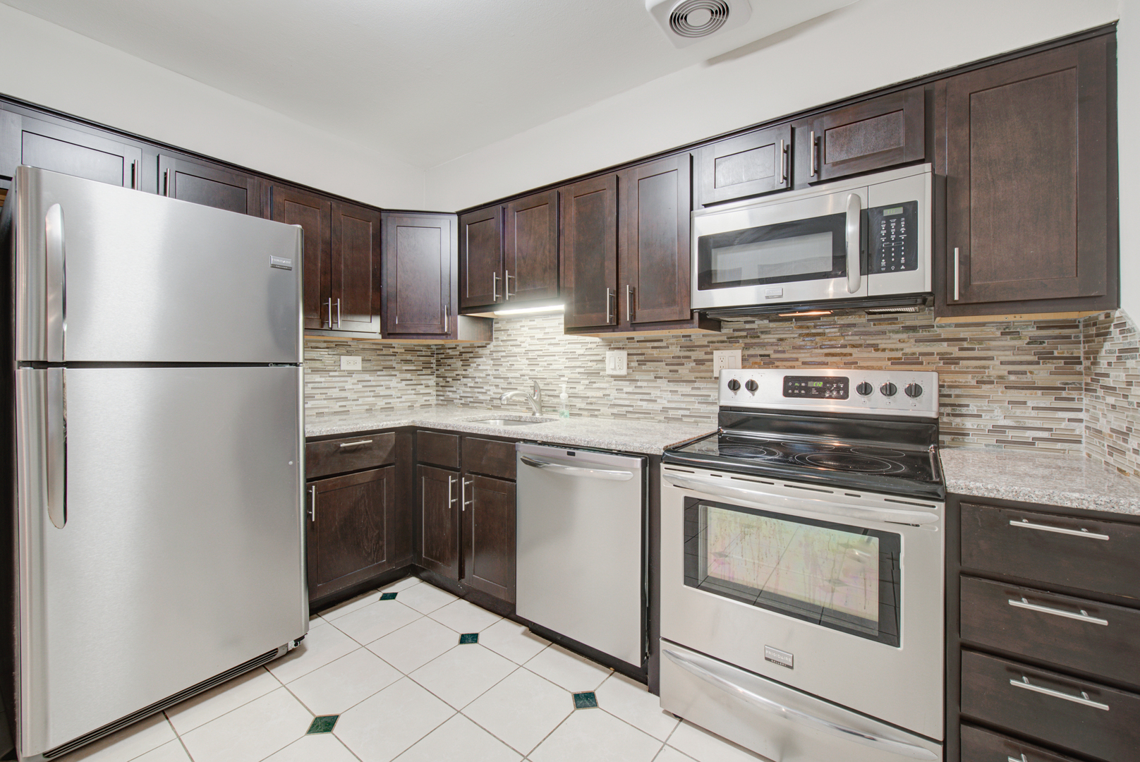 2323 South Goebbert Road, Unit 109 Arlington Heights, IL 60005 - Photo 9 of 22 a kitchen with stainless steel appliances granite countertop a refrigerator stove a sink and a microwave