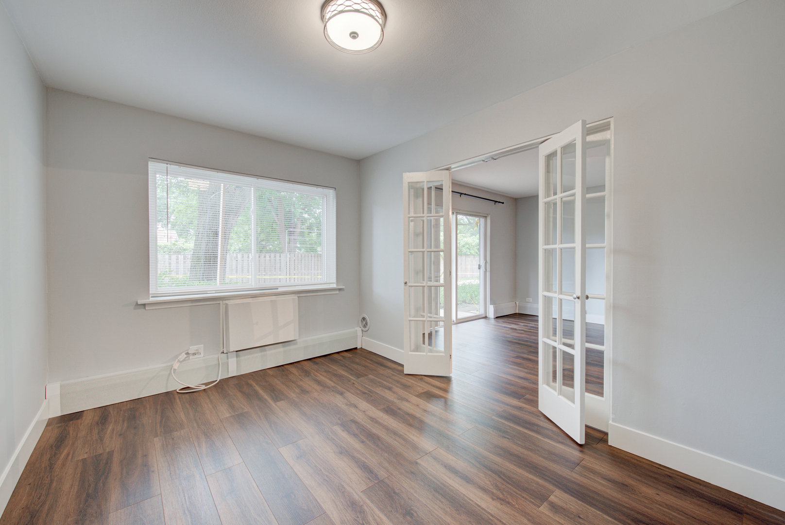 2323 South Goebbert Road, Unit 109 Arlington Heights, IL 60005 - Photo 10 of 22 an empty room with wooden floor and windows