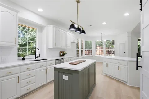 a large kitchen with stainless steel appliances kitchen island a refrigerator sink and cabinets