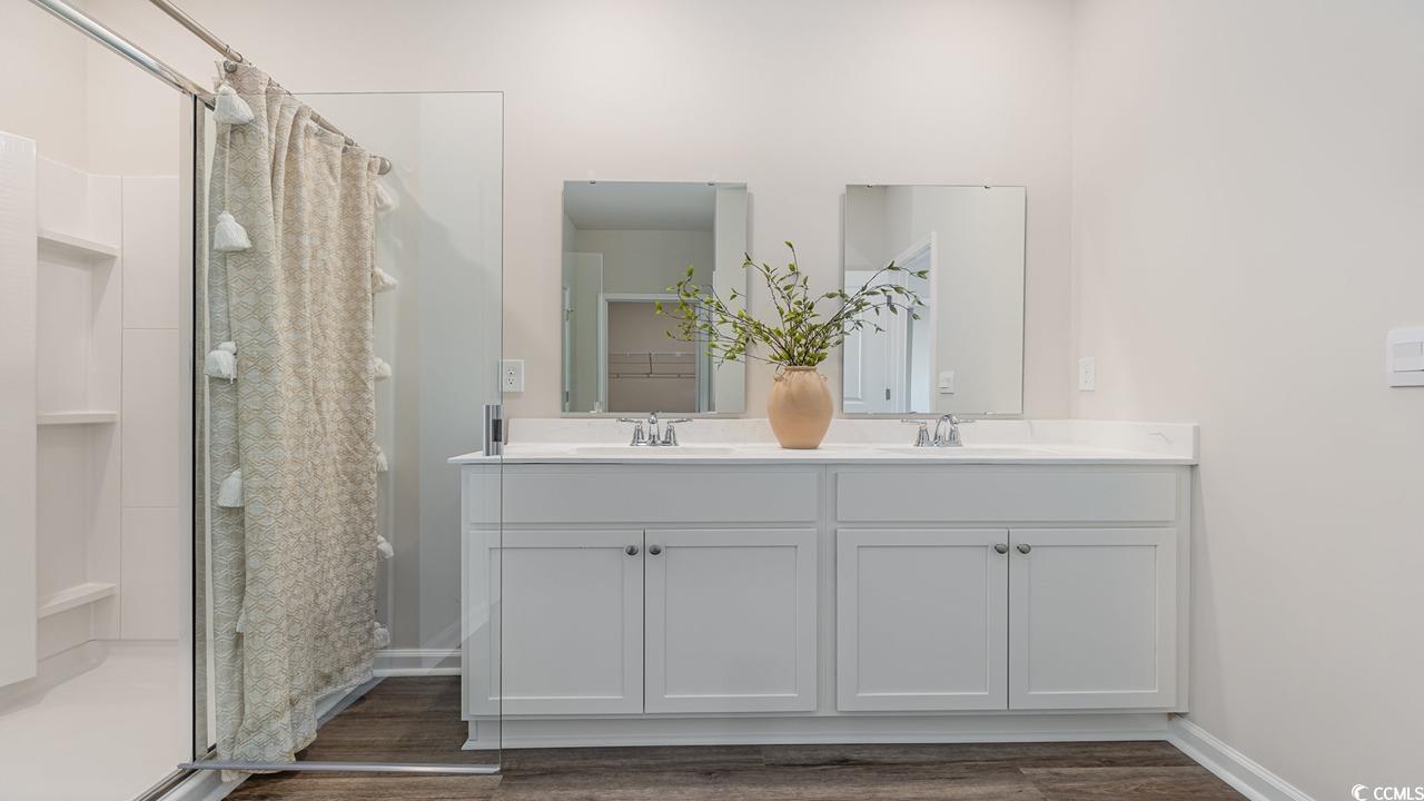 202 Dagger Court Myrtle Beach, SC 29588 - Photo 16 of 33 Full bathroom featuring a stall shower, double vanity, and dark wood-type flooring