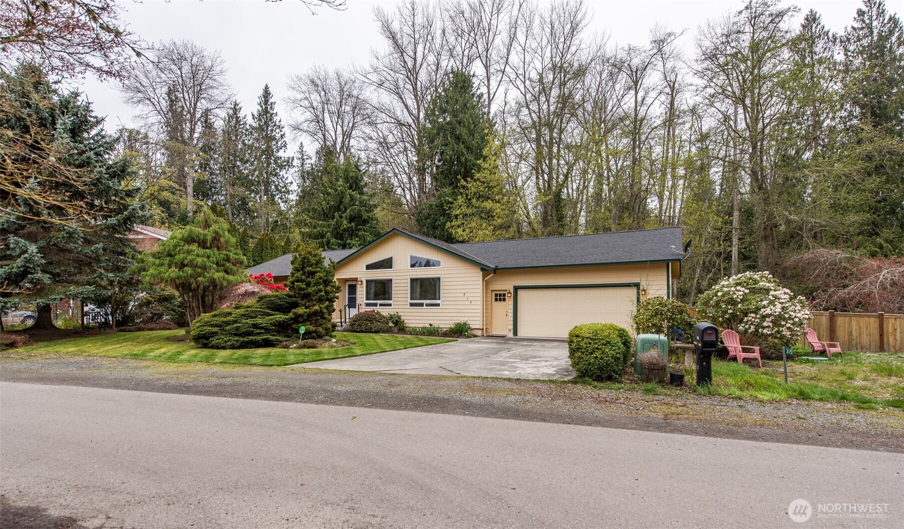 a view of a house with a yard and large trees