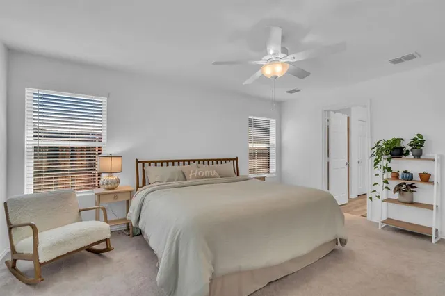 a spacious bedroom with a large bed and a chandelier