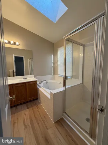 a large bathroom with a tub sink and mirror