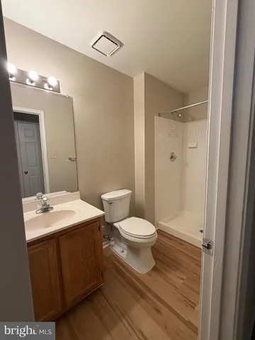 a bathroom with a sink a toilet a mirror and shower