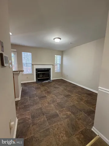 an empty room with fireplace and a window