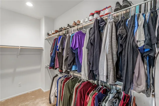 a view of walk in closet with clothes