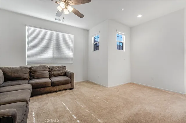 a living room with furniture and a ceiling fan